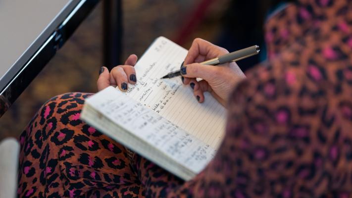 An attendee writing in a notebook
