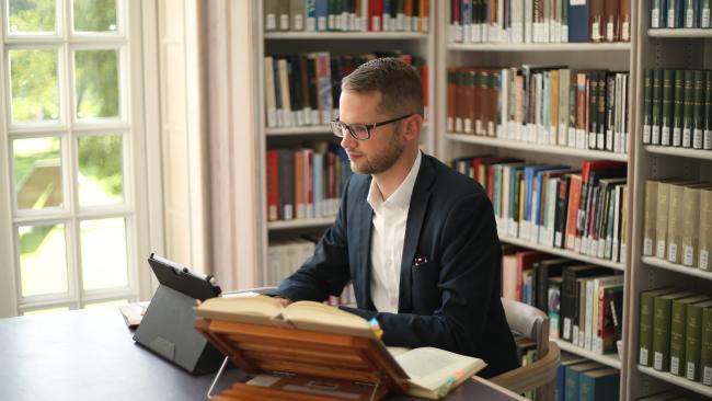 Dr Paul Dominiak working in the College library