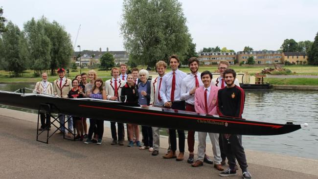 Image of Jesus College Boat Club members standing behind the new boat
