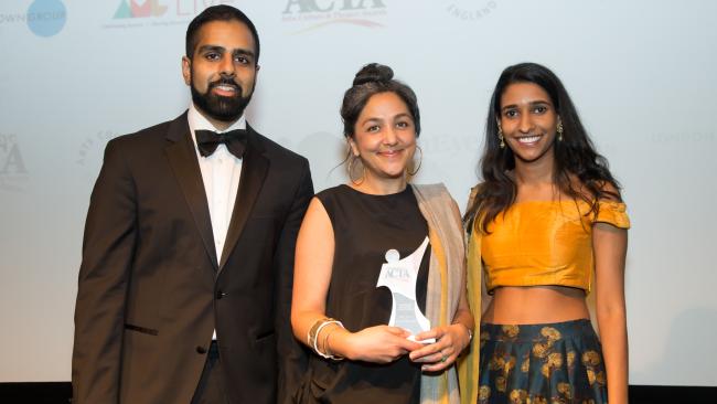 Image of Preti Taneja (middle) holding her award, with two representatives of the Asian Media Group.