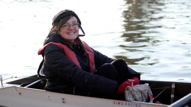 Image of Vicky sitting in a racing boat on a river