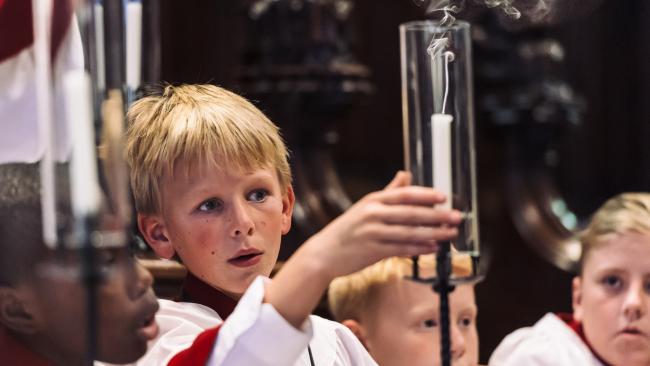 Choristers lighting candles