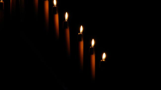 A row of candles in darkness