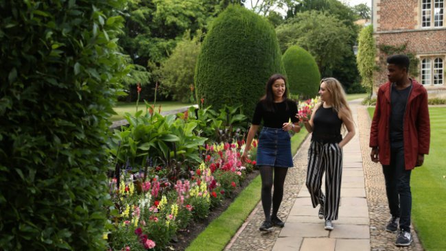 Students walking around the grounds of Jesus College.