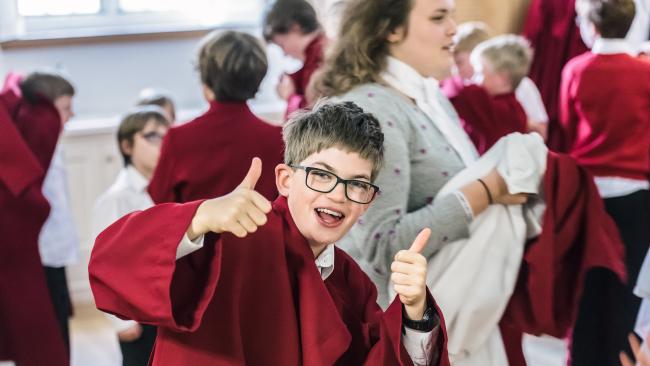 A chorister giving a thumbs up