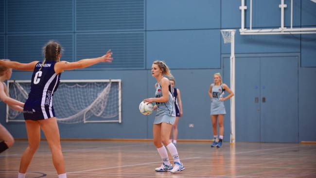Photo of Chloe Merrell playing netball in a University of Cambridge uniform