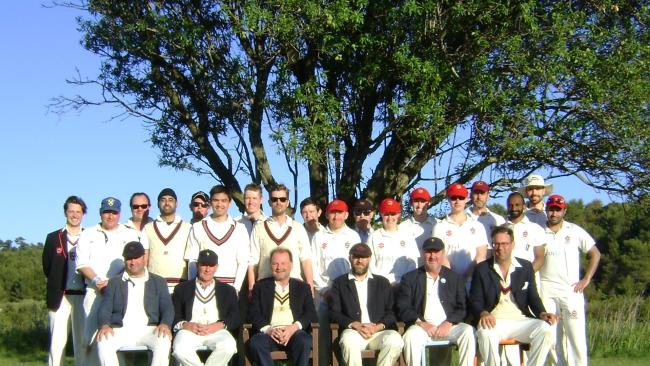 Jesus College and Royal Navy Volunteer Reserve cricket teams under an almond tree at the ground in Plisk