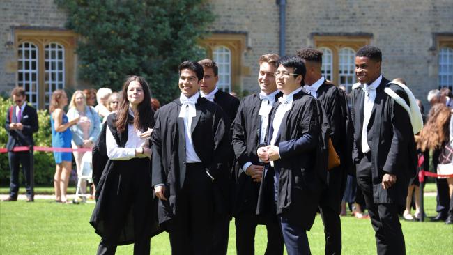 A group of students standing together, wearing graduation gowns