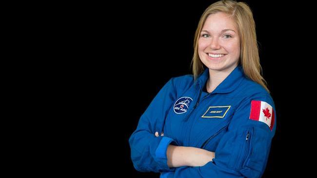 Official photo of Jenni Sidey in a blue jumpsuit with a Canadian Flag emblem at the top of her arm