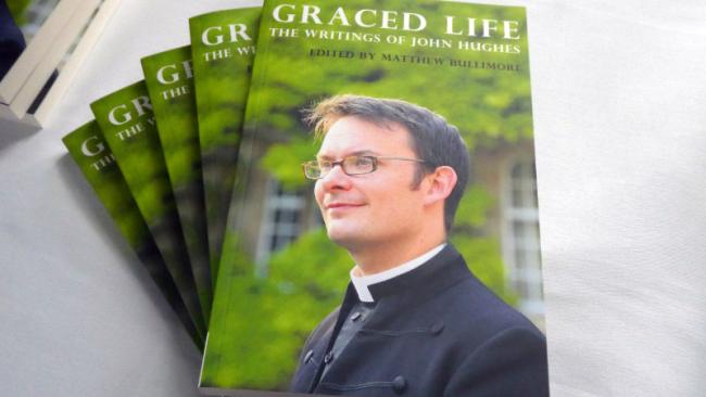 Photograph of copies of Graced Life: The Writings of John Hughes (1979-2014)